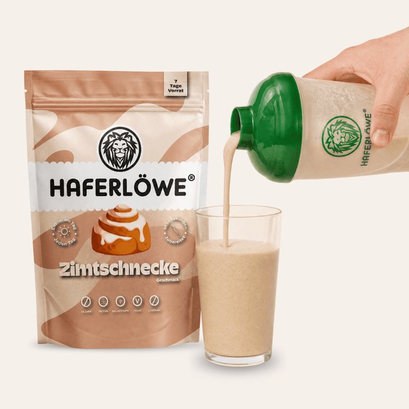 HAFERLÖWE Tüte Zimtschnecke, daneben wird ein Shake aus dem Shaker ins Glas gegossen